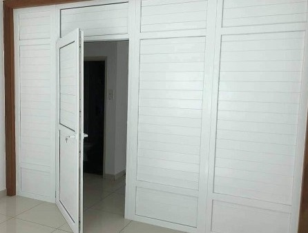 white uPVC louver panel door fitted in interior wall partition inside house